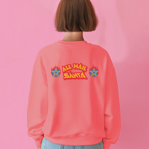 A Christmas sweatshirt featuring a playful design with a cartoon Baphomet goat character wearing a Santa hat. The design includes the text "All Hail Santa" above the goat, with pentagrams in flames on either side. The goat is depicted in a meditative pose, adding a humorous and irreverent twist to holiday attire.